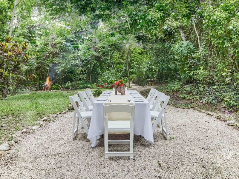 Dining table arranged for a private event outdoors with lush greenery at The Explorean Resorts