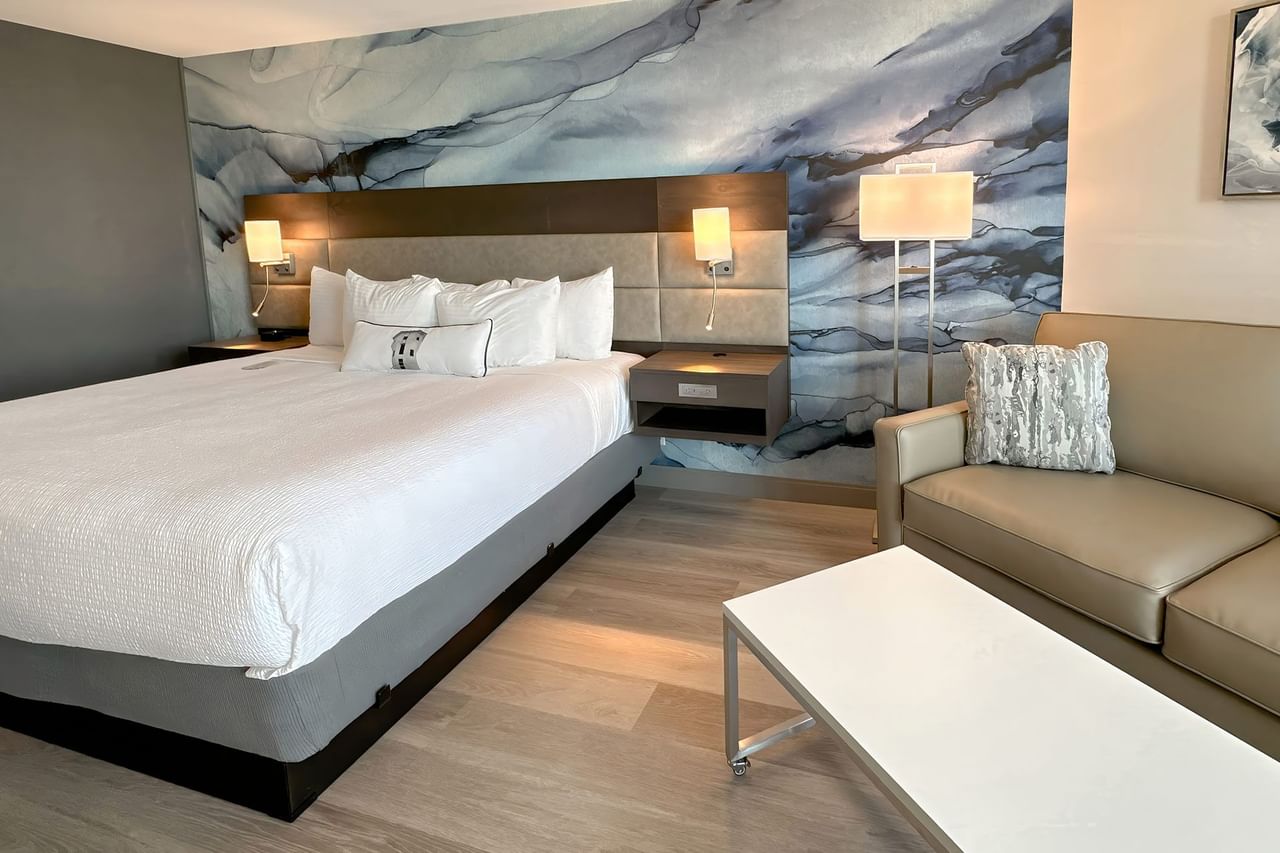 Hotel guestroom with king bed and a blue wall mural