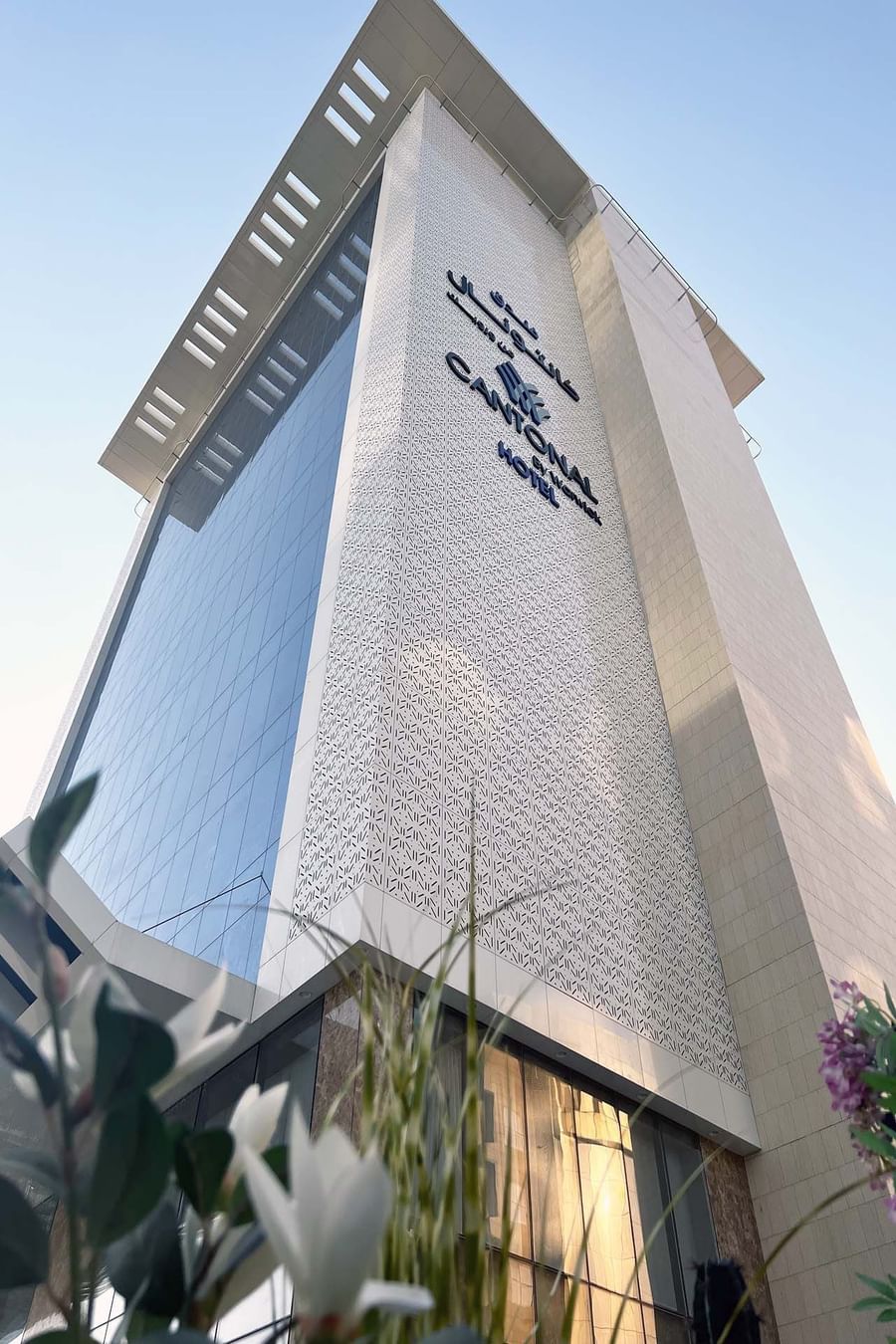 Exterior view of Cantonal Hotel by Warwick Riyadh featuring patterned panels by a glass facade