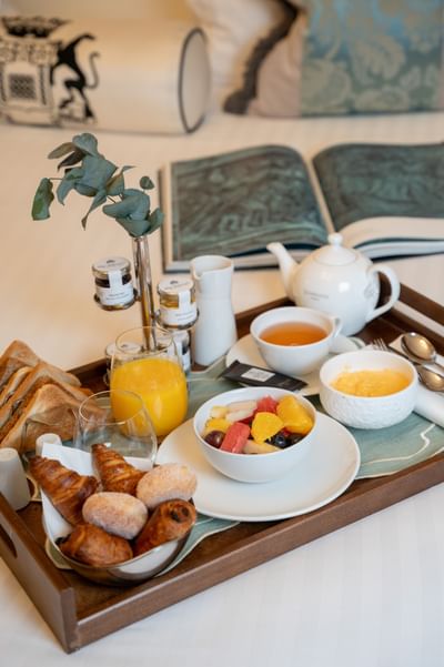 Plateau de petit-déjeuner avec viennoiseries, fruits frais, thé et jus d'orange à l'Hotel Westminster Warwick Paris