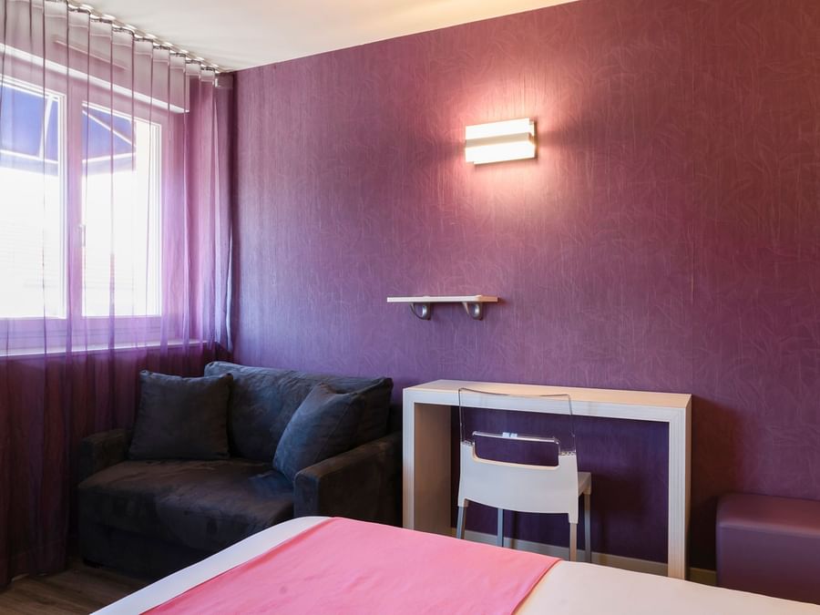A bedroom with a sofa  & furniture at Hotel le Saint-Martial