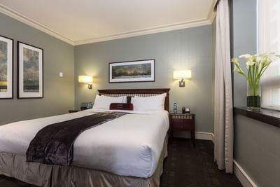 Nightstands by the bed in Executive King Guest Room with artwork on the walls at The St. Regis Hotel Vancouver