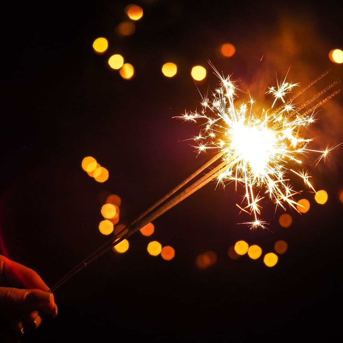 Close-up of a person's hand holding sparklers at Porta Hotel Antigua