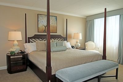 Comfy large bed with foot rest in a room at Ethan Allen Hotel