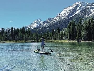 Lady paddle boarding in a Lake with a view near Hotel Jackson