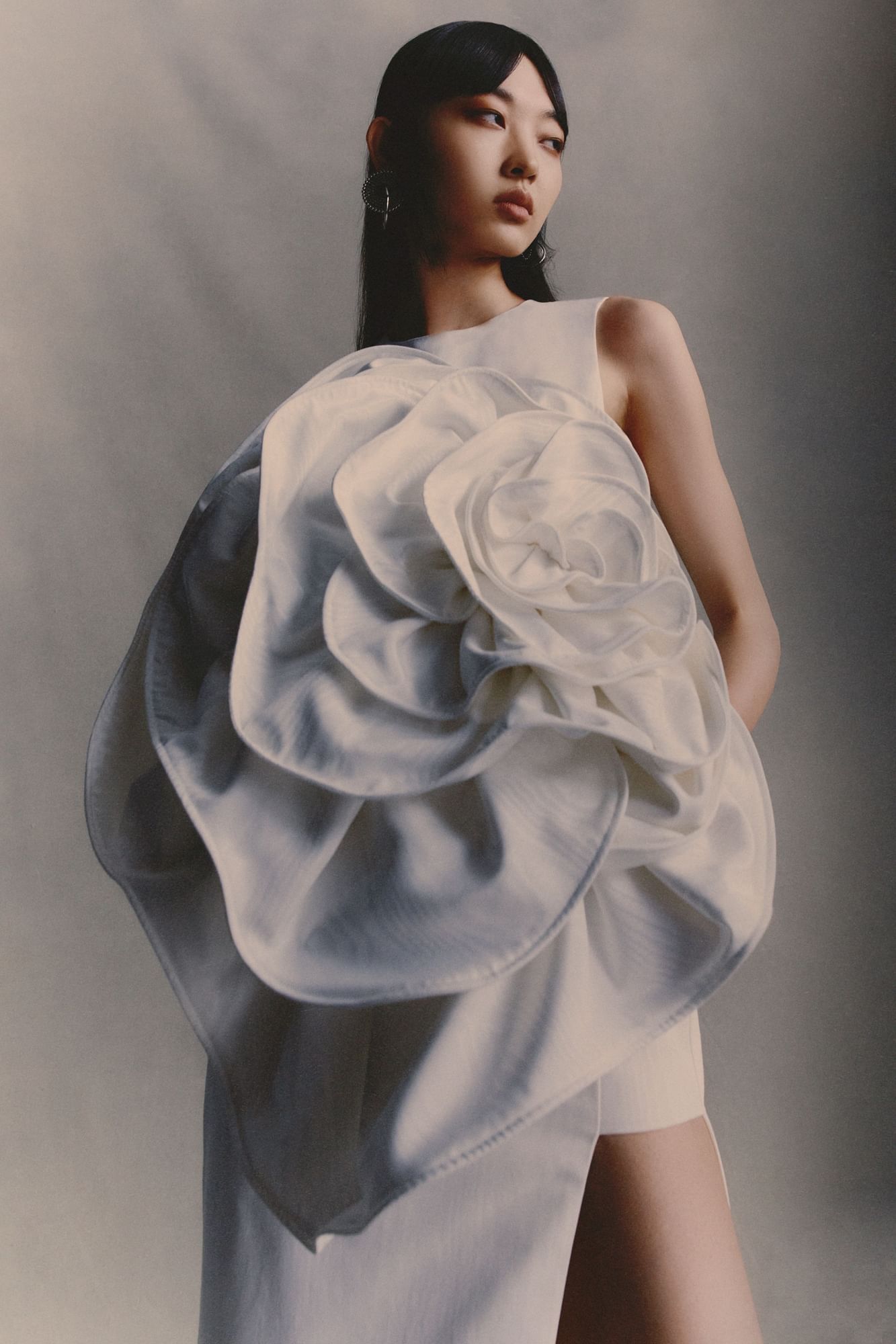 Model wearing stunning Huishan Zhang's white dress with large intricate floral detail near The Londoner