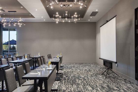 chairs and tables facing a projector screen