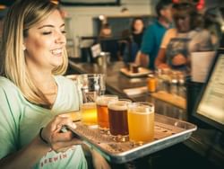 woman holding beer flight