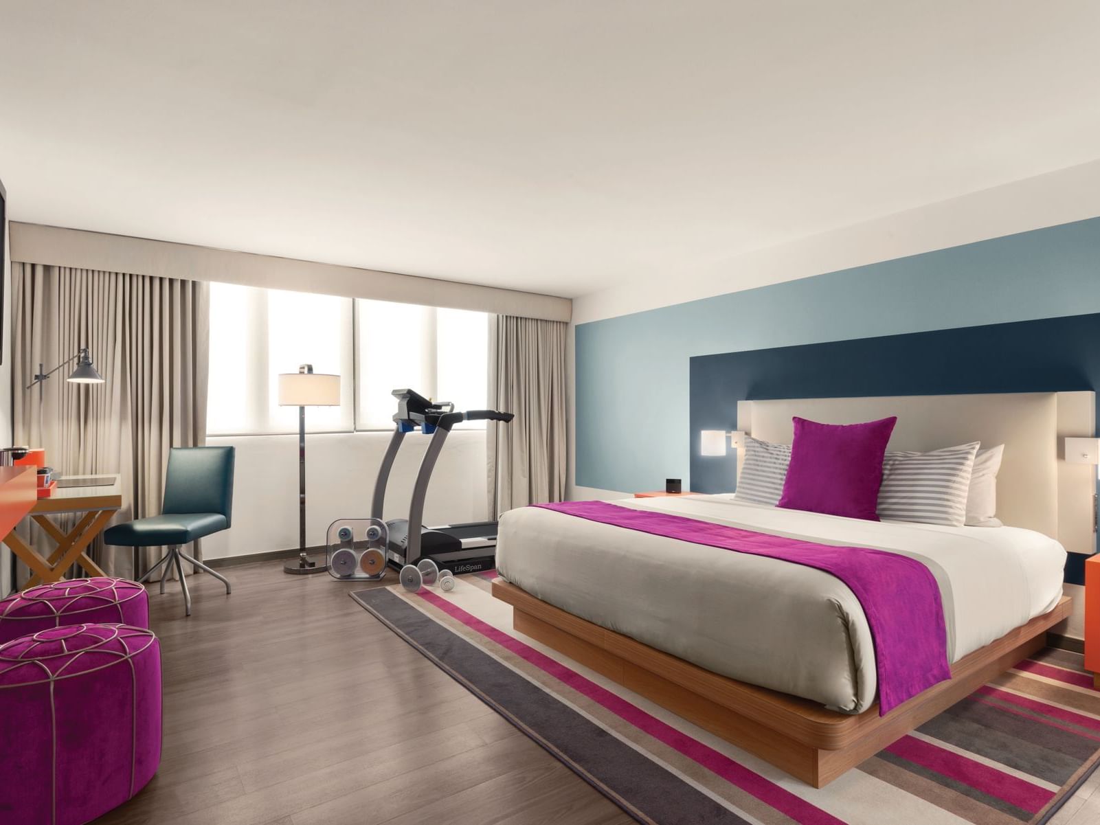 TRYP by Wyndham Isla Verde hotel room with king bed, treadmill and dumbbells near desk