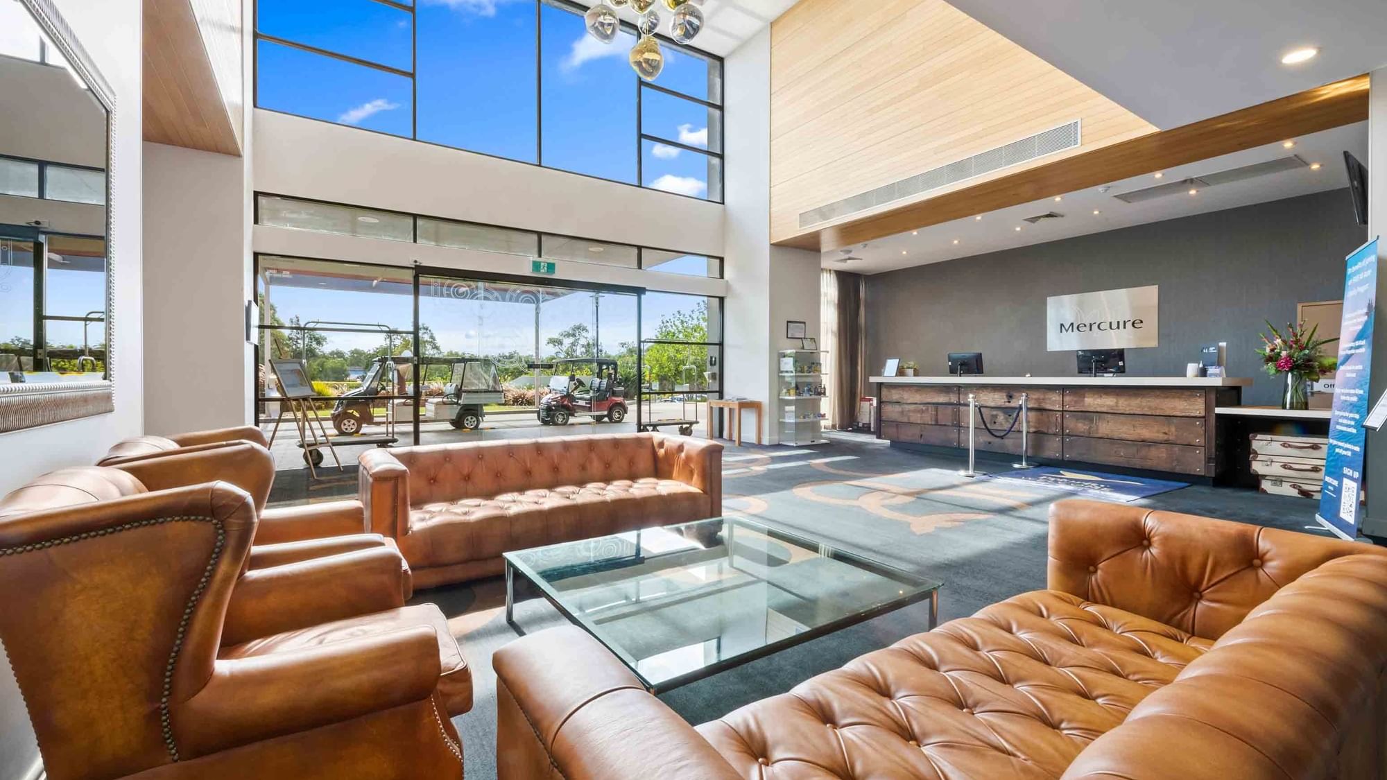 spacious lobby with high ceilings and large windows with natural light at Mercure Kooindah Waters