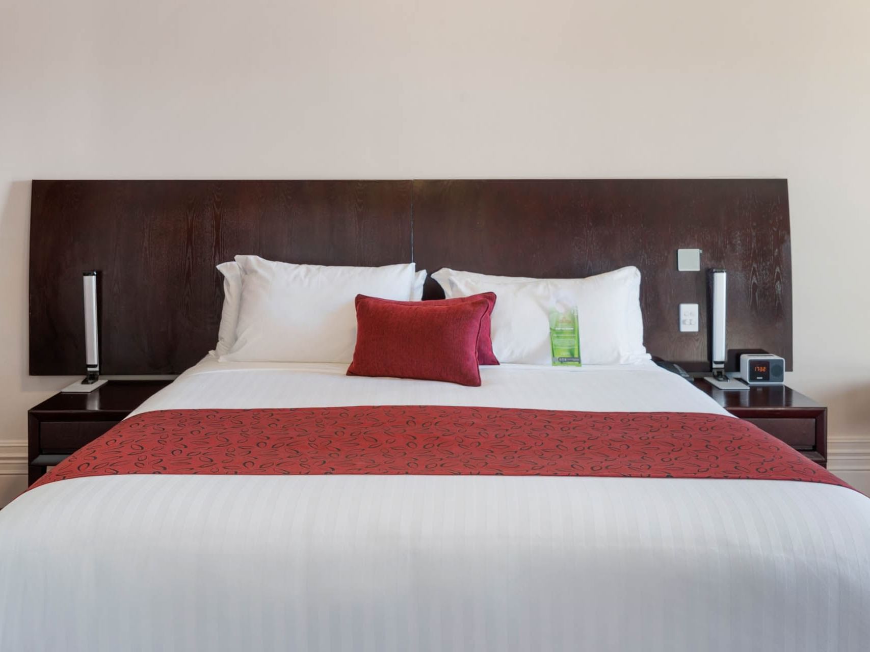 Large bed with pillows and side desks arranged in The State Suite at Hotel Grand Chancellor Launceston