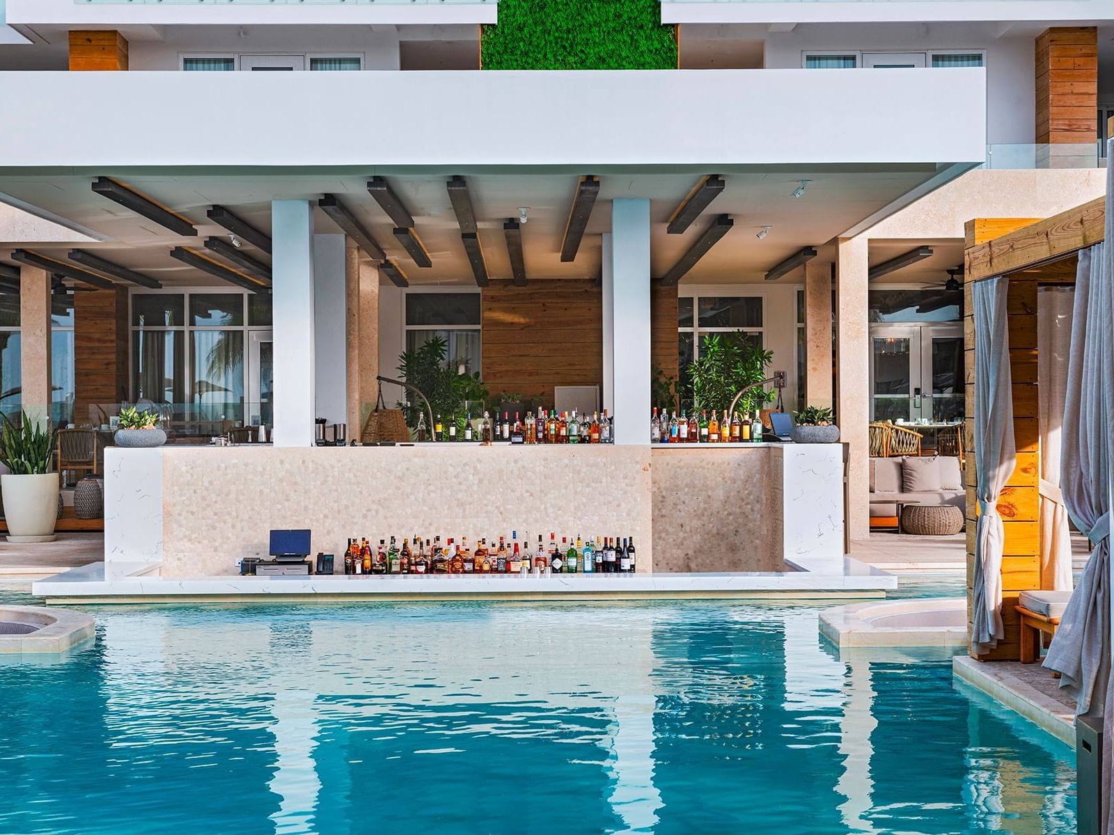 Terrace pool bar with plenty of drinks at Alaia Belize Autograph Collection