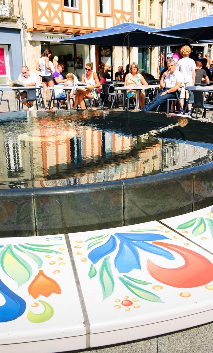 Les gens dînant à l'extérieur à côté d'un étang près des Hôtels Oceania