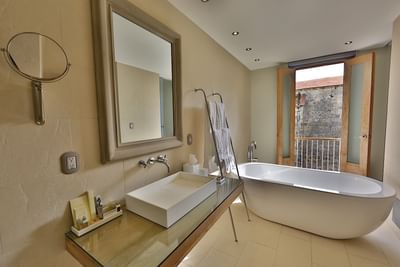Cathedral View Executive Suite bathroom with a freestanding tub and vanity at Billini Hotel Historic Luxury