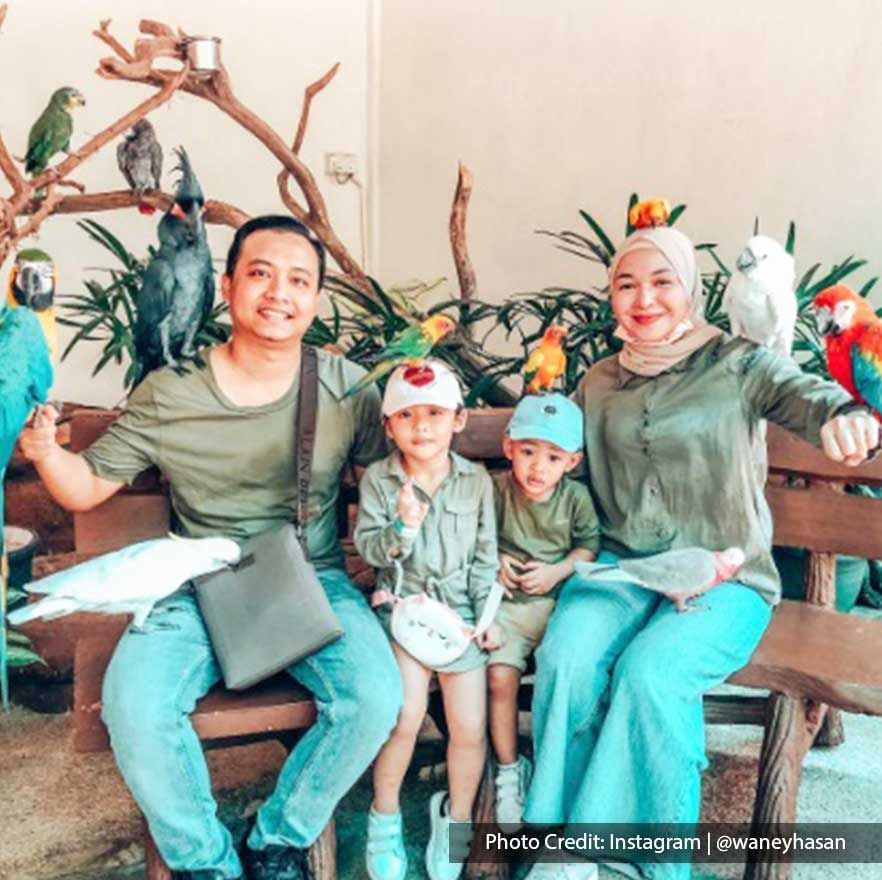 Family posing with Macaws in KL Bird Park, a fun-filled attraction site near Imperial Lexis KL