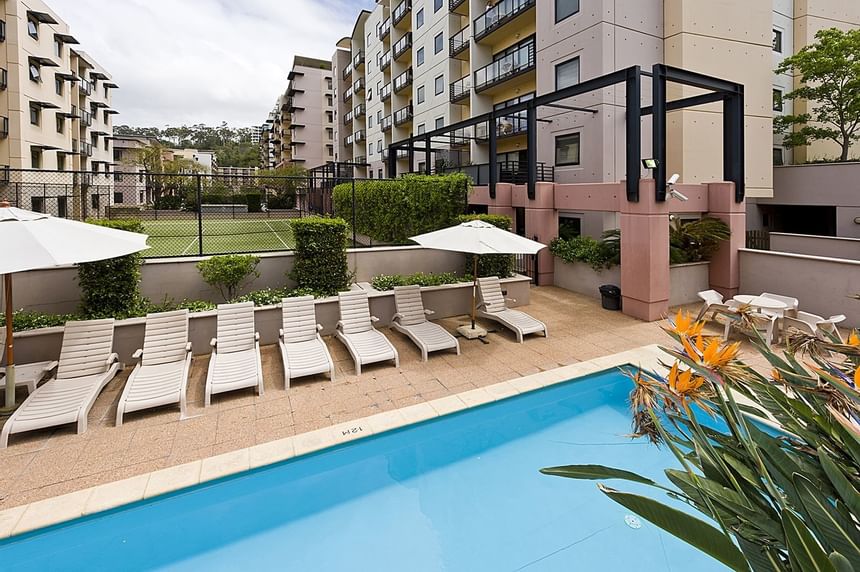 Sunbeds by the outdoor pool area at Nesuto Mounts Bay