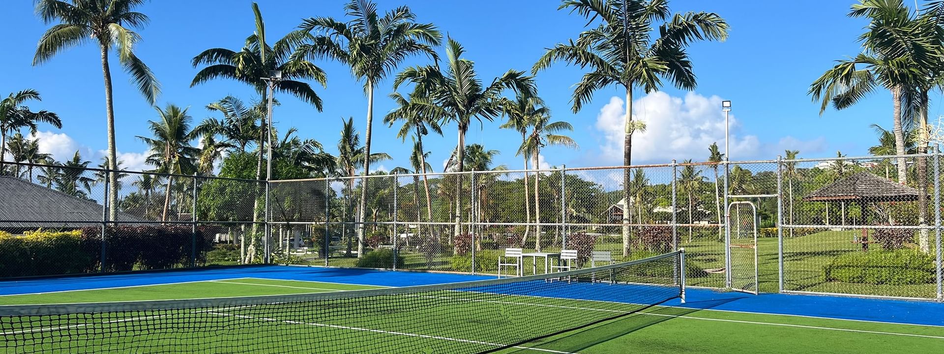 Tennis court with blue and green turf and net at Warwick Le Lagon - Vanuatu, Efate