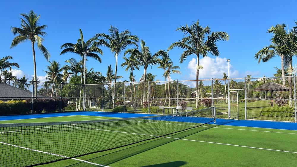 Tennis court with blue and green turf and net at Warwick Le Lagon - Vanuatu, Efate.