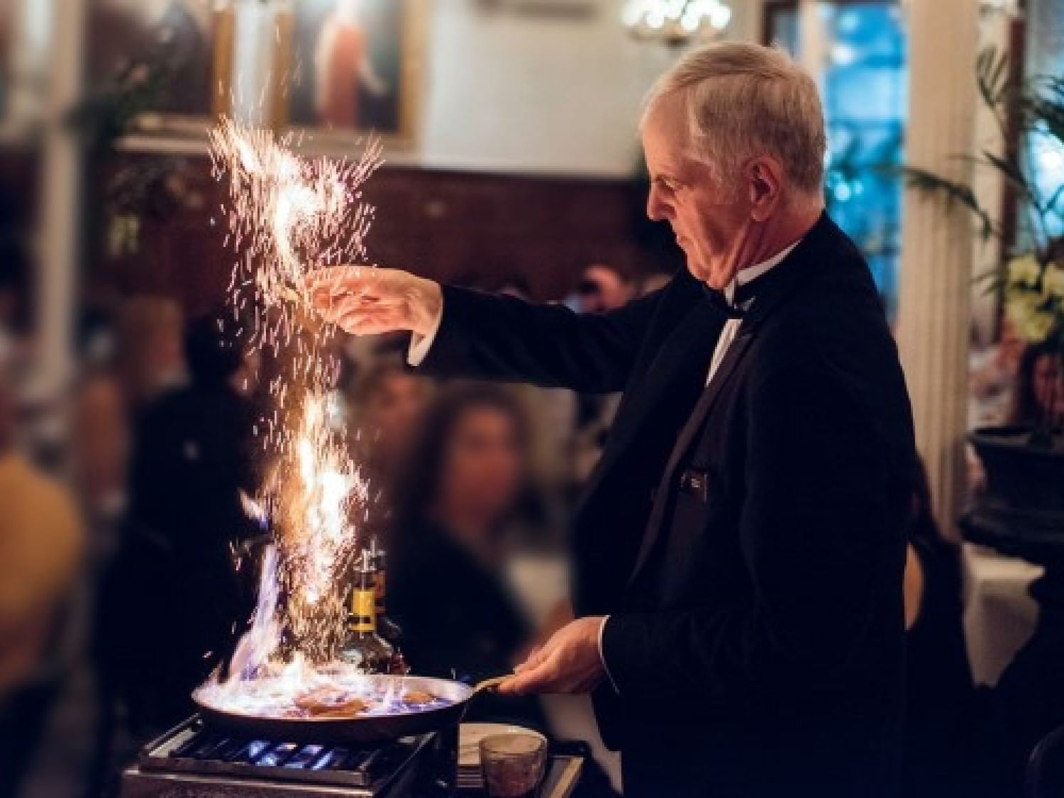 A waiter flambéing a dish at Arnaud's near St. James Hotel