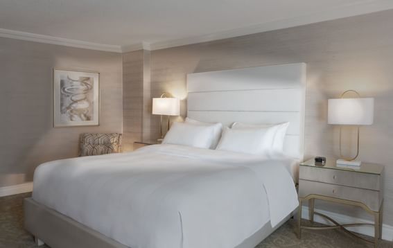 Bed & nightstand in Essential King Room at Chateau Vaudreuil