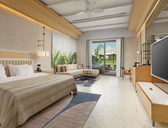 TV & seating area by the bed in Lagoon Golf Swim-up Room at Cullinan Belek