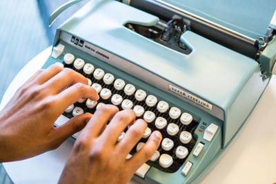 A person typing on the typewriter at The Verb Hotel