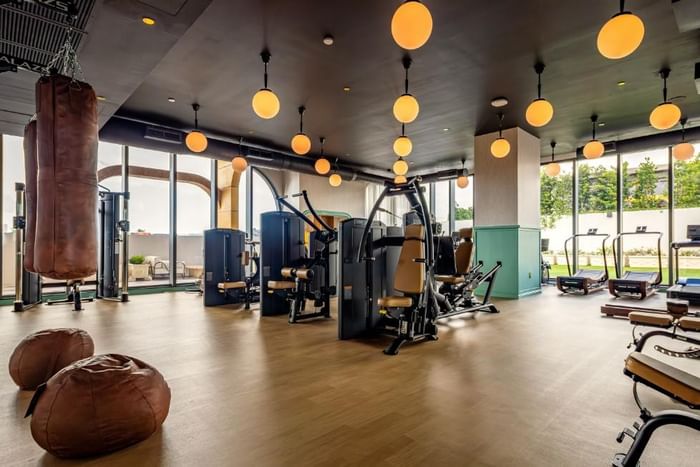 Modern gym with leather bags and bean bags, gym machines, and circular lights at The 27 Wynwood