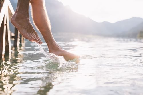 Close-up of a man splashing water by his legs near Liebes Rot