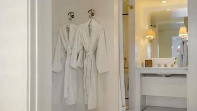 Bathroom vanity with two bathrobes hanging on hooks at Pavilion Hotel Catalina Island