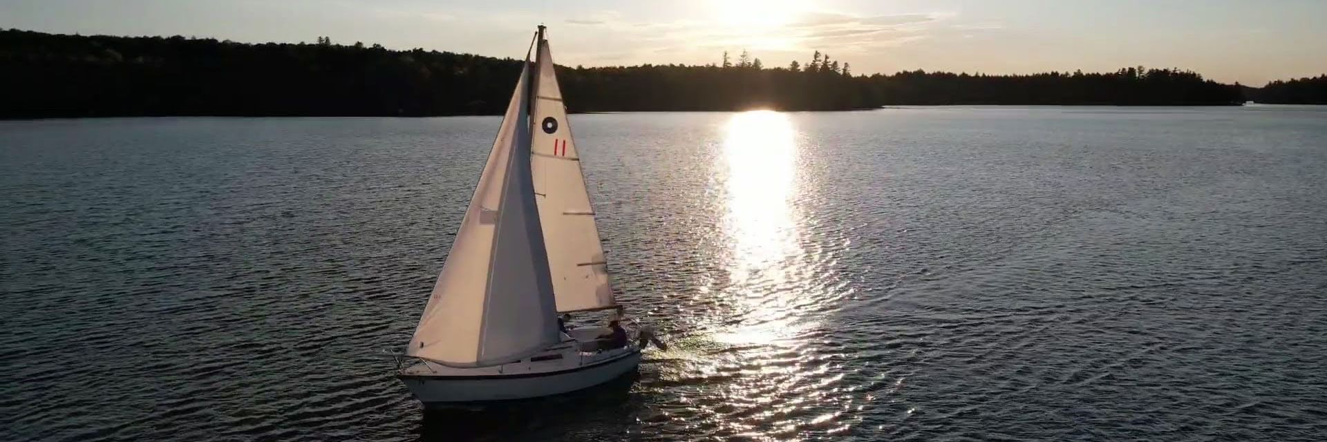 Sail boat on lake at sunset.