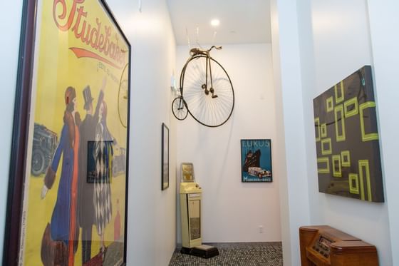 Penny-farthing bike & wall arts in a hallway at Retro Suites