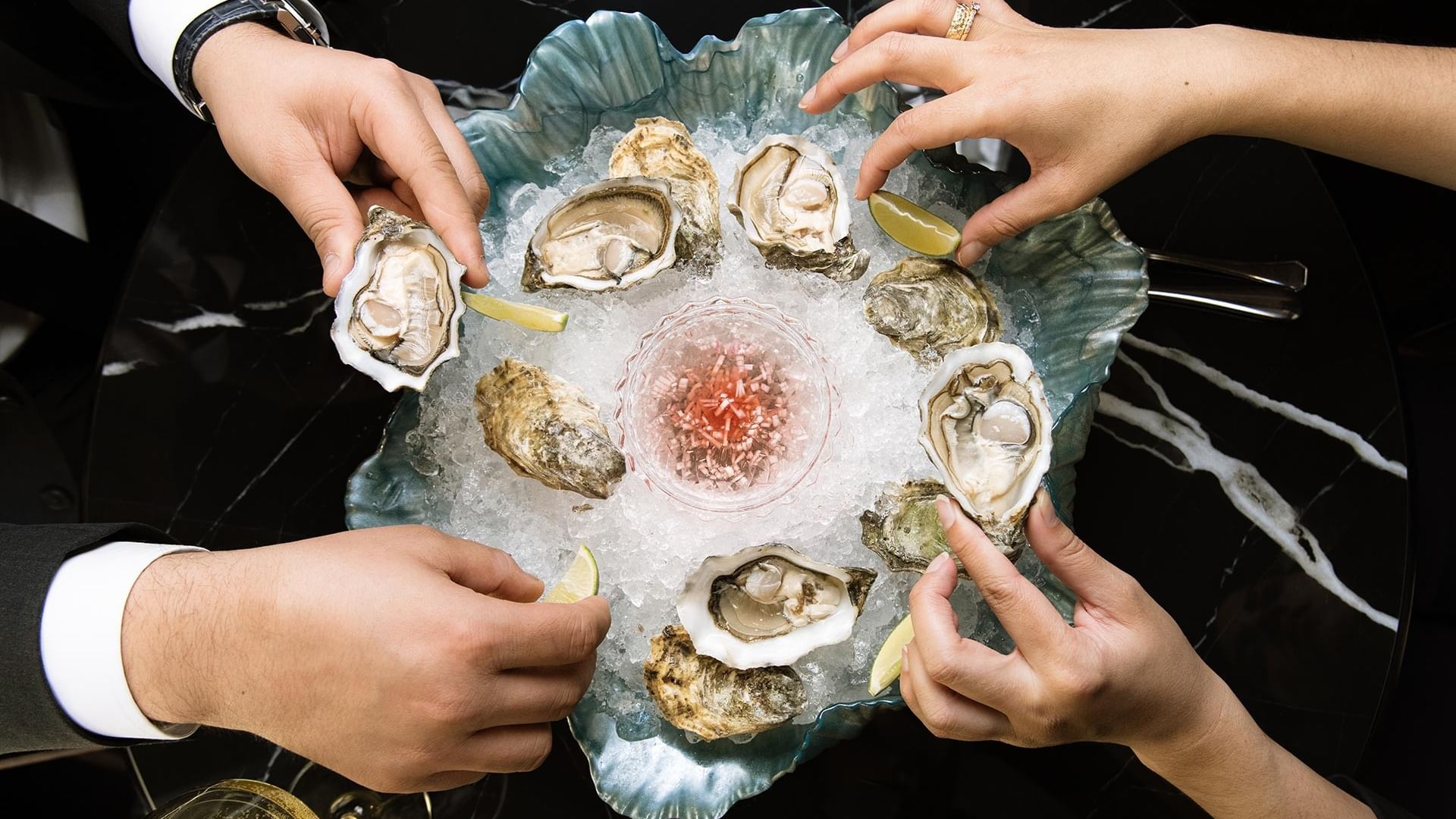 Fresh oysters on ice with mignonette sauce being shared by guests at Titanic Gendarmenmarkt Berlin