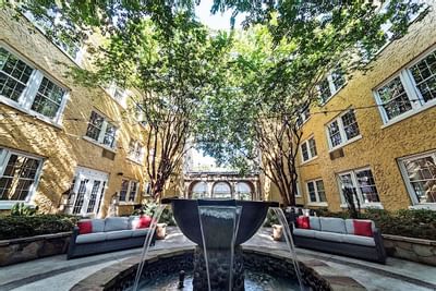 A fountain covered by trees at Artmore Hotel