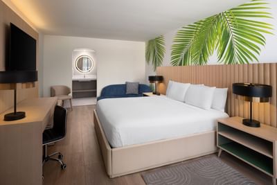 Premium King room featuring a tropical palm leaf mural and work desk area at The Harrison Hotel Downtown Hollywood