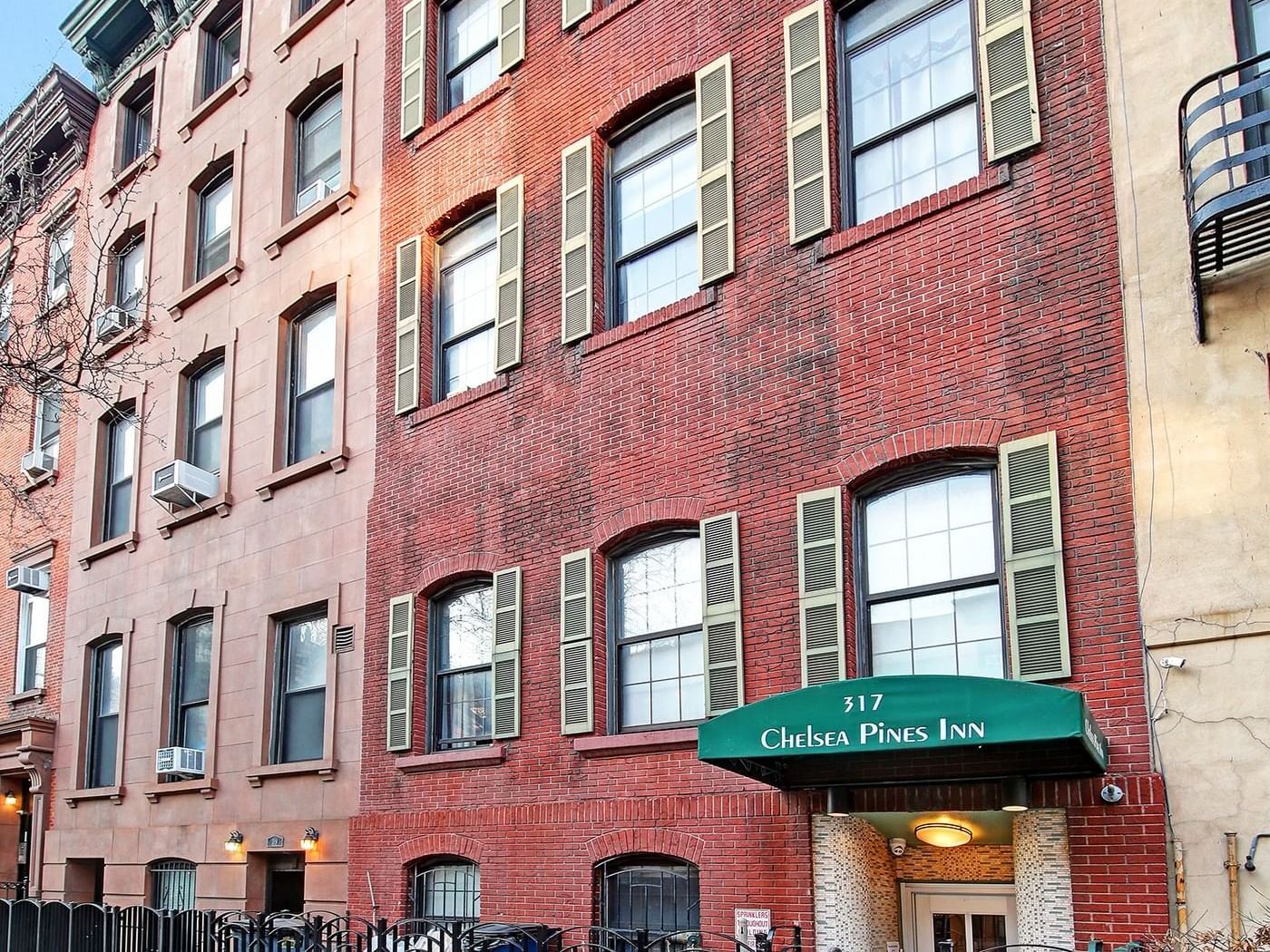 Red brick building with Chelsea Pines Inn sign and 7 Nights Stay Or Longer 15% Off offer.