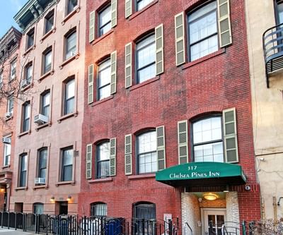 Brick building with multiple windows, green awning, and 