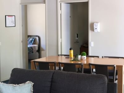Living area with a couch and dining table at La Trobe University - Villas.