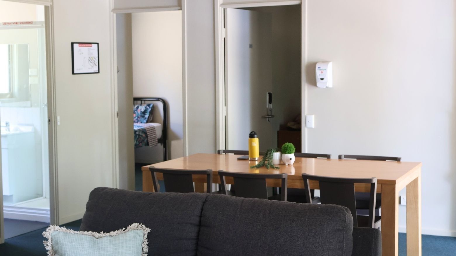 Living area with a couch and dining table at La Trobe University - Villas.