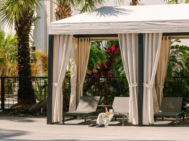 Things to do in South Beach​ in a private cabana with comfy loungers and lush greenery at the Kenmore Village Hotel