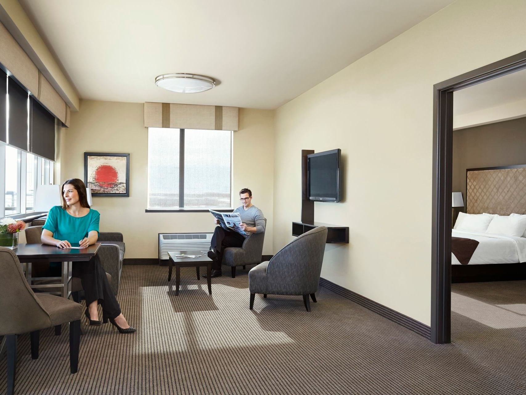 Lounge area with TV in Diamond King Suite at Acclaim Hotel Calgary