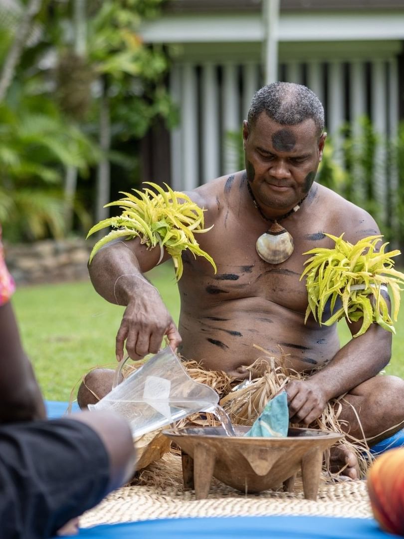 Cultural kava ceremony by guests on mats under tropical trees at Warwick Hotels and Resort