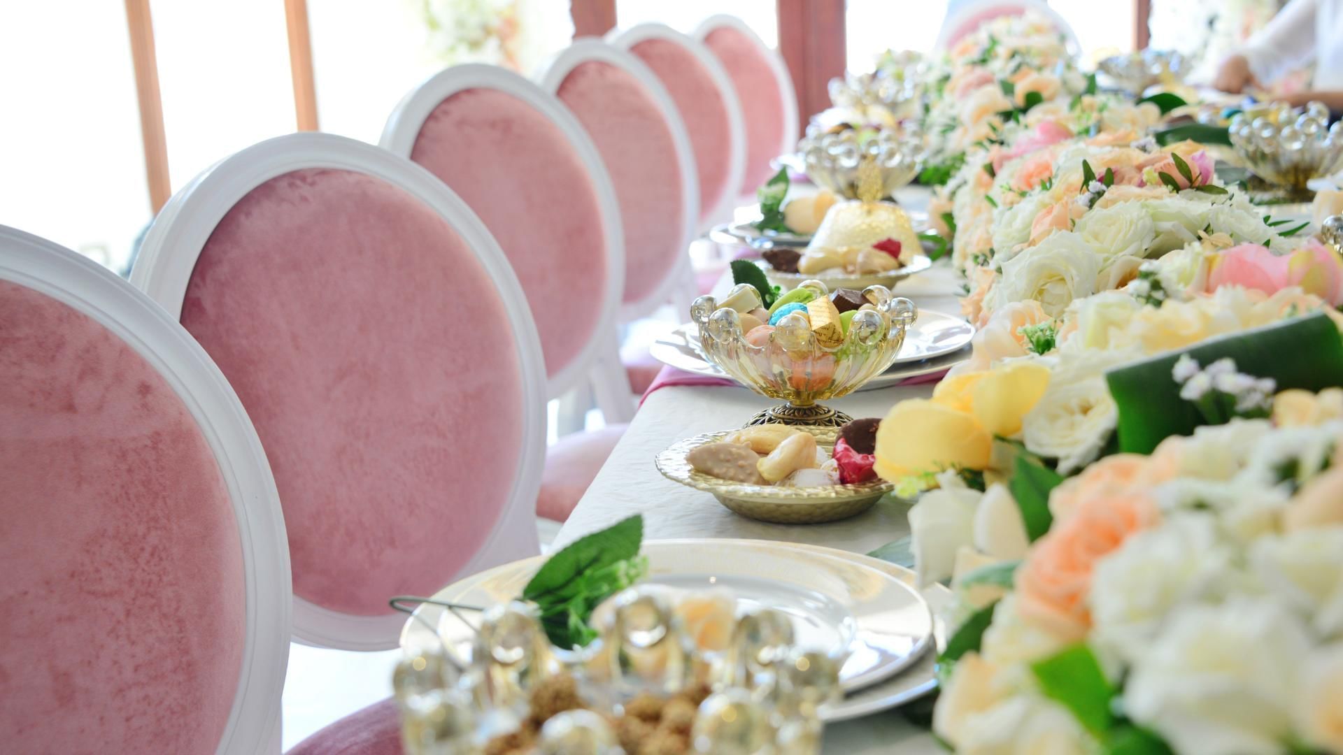 Jewish Wedding Venues table settings with pink chairs and colourful flower arrangements