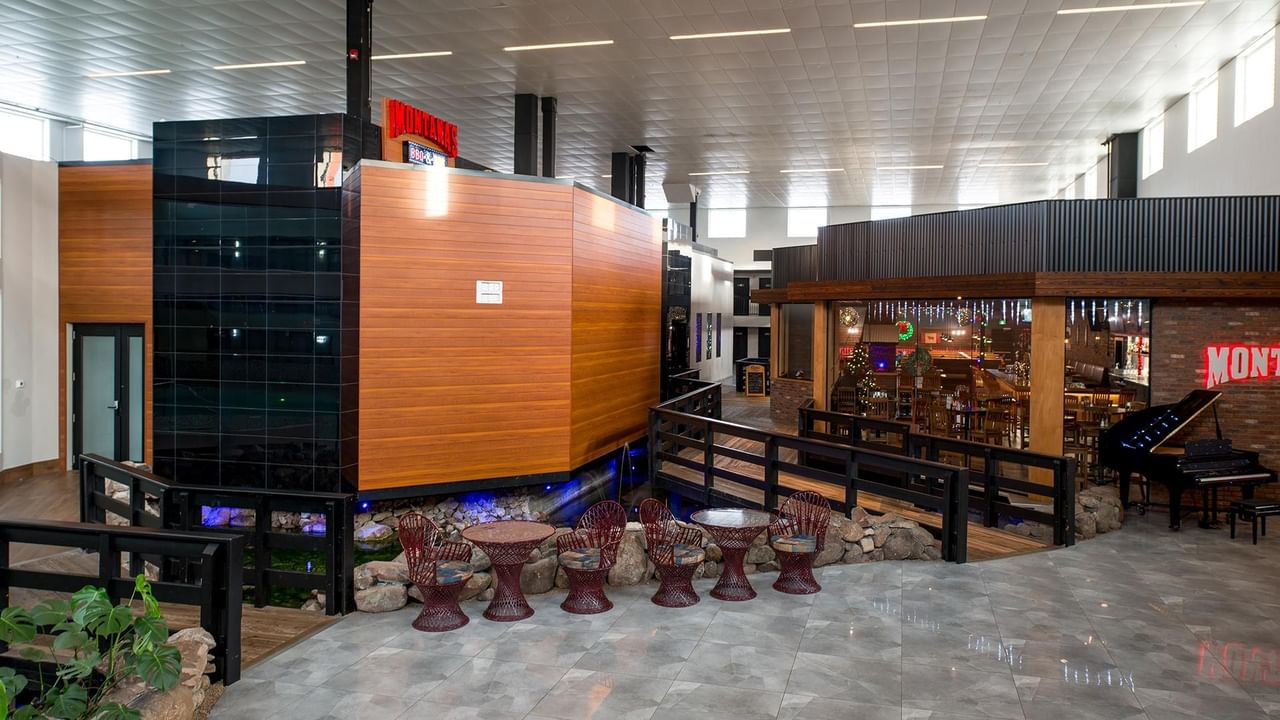 Hotel atrium area with chairs, tables, and a piano.