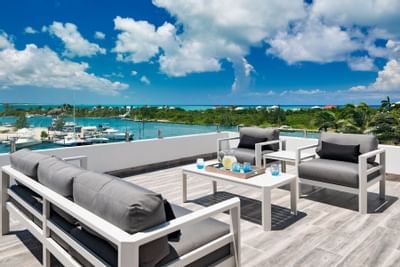 Grey sofa and armchairs on the rooftop lounge at Zenza Hotel turks and caicos hotel with rooftop sunset lounge