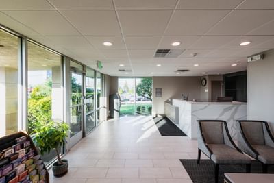 Spacious lobby with a marble reception desk & comfortable seating at Garden Executive Hotel in South Plainfield, NJ