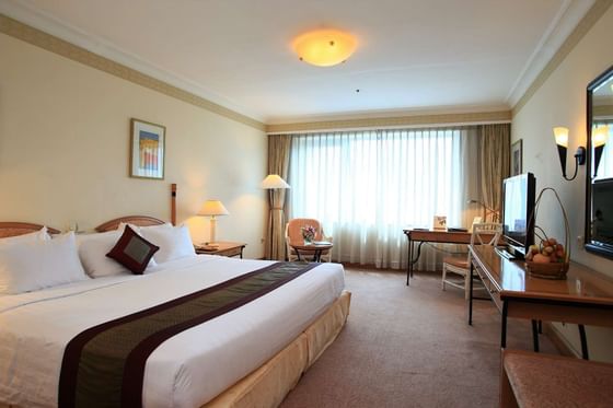 King bed and a TV in Deluxe Room at Hanoi Daewoo Hotel