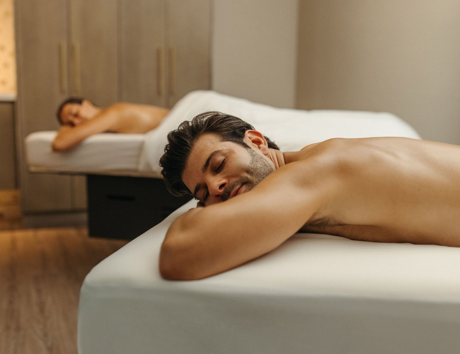 Couple relaxing on comfortable massage tables during a peaceful wellness spa treatment session at Hotel X Toronto