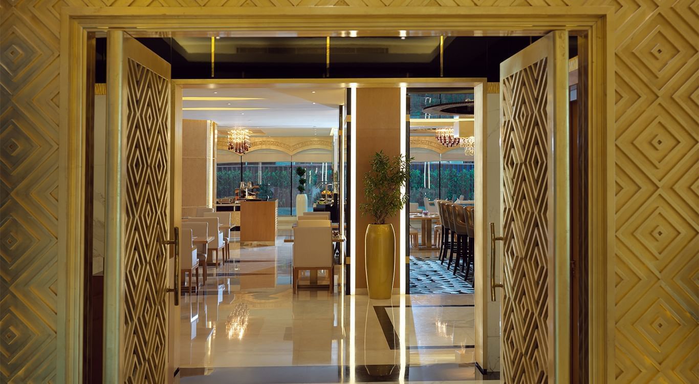 The dining area viewed through open double doors at DAMAC Maison Mall Street
