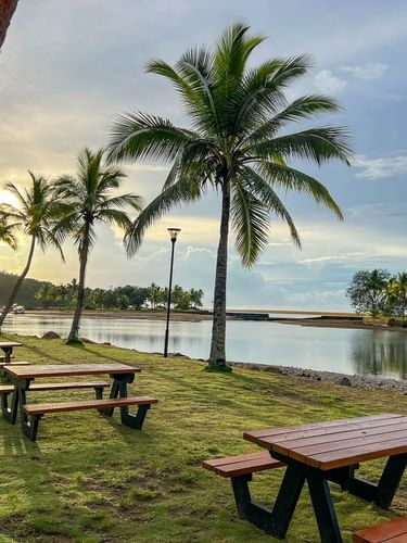 Wooden picnic tables near the lake at Nukunuku Restaurant & Bar in Korolevu at The Naviti Resort - Fiji