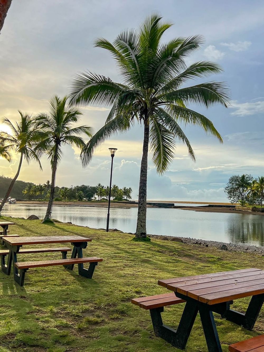 Wooden picnic tables near the lake at Nukunuku Restaurant & Bar in Korolevu at The Naviti Resort - Fiji.